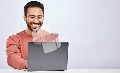 Image of Business, smile and asian man with laptop on studio for research, typing or social media on grey background. Happy, search and male freelancer online for design, blog or project, creative or planning