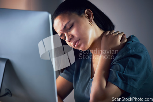 Image of Business woman, neck pain and night in burnout, stress or fatigue by computer at office. Frustrated, overworked and tired female person with sore shoulder, muscle or tension working late at workplace