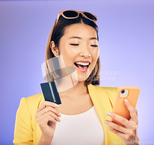 Image of Credit card, phone and woman online shopping, e commerce or fintech payment on studio purple background. Excited, loan and happy asian person for internet banking, subscription or mobile transaction