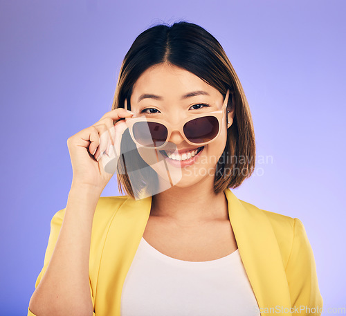 Image of Happy asian woman, portrait and sunglasses for fashion or stylish accessory against a purple studio background. Female person or model with smile in satisfaction or relax for summer style or clothing