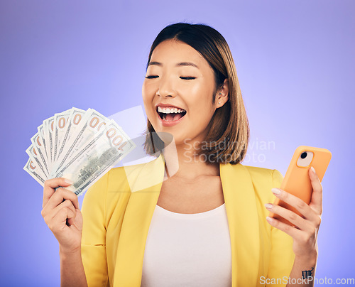 Image of Money, phone and woman with wow for winning, finance or online savings, profit and cash prize. Success, lottery and winner or asian person on mobile, money fan and banking on studio purple background