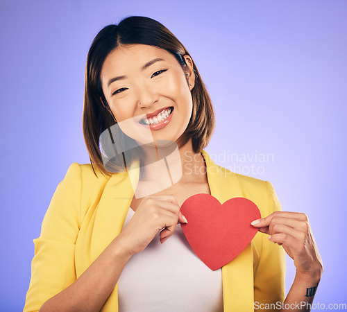Image of Support, asian girl and care with paper heart with portrait in purple studio or background with emotion. Woman, happy and face with love sign for peace or kindness with emoji shape for hope or smile.