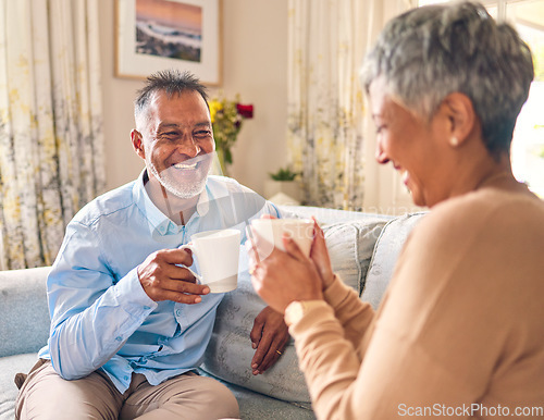 Image of Coffee, laughing and a senior couple on a sofa in the home living room to relax while bonding in conversation. Smile, retirement or love with a mature married man and woman talking while drinking tea