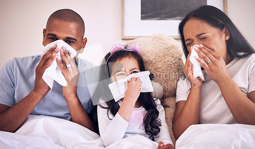 Image of Family, sick and blowing nose on a bed together in a bedroom with allergy or virus and wipe with tissue. Disease, mother and father with kid or child with cold, flu and in winter as parents and girl