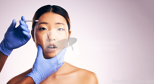 Image of Asian woman, hands and needle for plastic surgery in studio for cosmetics, mockup space or collagen on a white background banner. Beauty, doctor and syringe for patient, change with pain on face