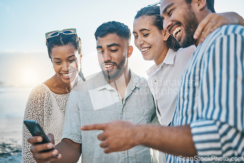 Image of Friends, together and phone at ocean with laughing or meme on holiday or weekend to relax. Cellphone, beach and couple with group are happy on vacation with social media in summer for fun in outdoor.