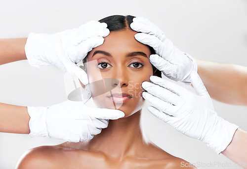 Image of Woman, plastic surgery and hands in studio portrait with beauty, skincare and face with process by white background. Change, model and doctors gloves for transformation, cosmetics or facial aesthetic