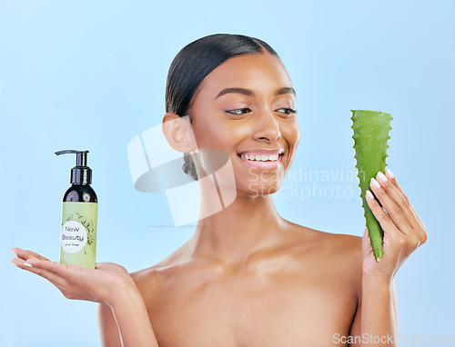 Image of Woman, aloe vera and skincare in studio with smile, natural choice and happy by blue background. Girl, model and cactus plant for health, wellness and bottle with serum for self care, facial and glow