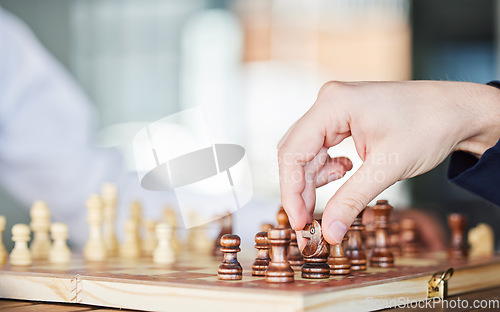 Image of Chess, board game and hand of a man playing at a table while moving piece for strategy or checkmate. Person with wooden icon to play, relax and bond or problem solving and battle in competition