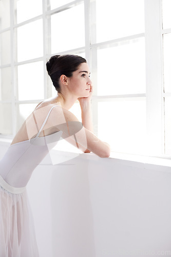 Image of Woman, ballerina and thinking by window in ballet for dance, vision or doubt in the art studio. Female person or dancer looking out glass in decision, think or dream with dancing costume indoors