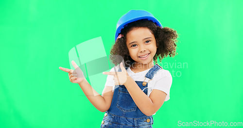 Image of Kids, construction and a girl on a green screen background in studio pointing at building space. Children, architecture and design with a cute female child engineer wearing a hardhat on chromakey