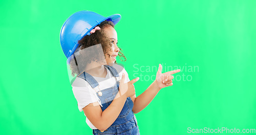 Image of Children, construction worker and a girl on green screen background in studio pointing at building space. Kids, architecture or design with a cute female child engineer wearing a hardhat on chromakey