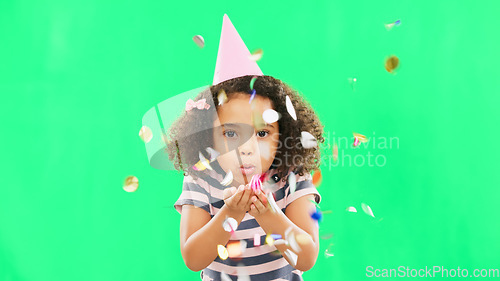 Image of Little girl, birthday and blowing confetti on green screen for party celebration isolated against a studio background. Portrait of cute kid celebrating event with glitter decor for new year on mockup