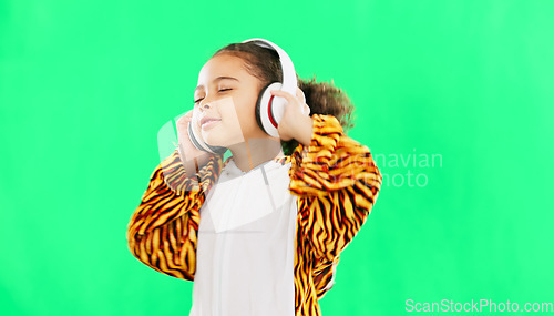 Image of Children, music and dance with a girl on a green screen background in studio streaming audio while having fun. Kids, energy and freedom with a little female child dancing while listening to the radio