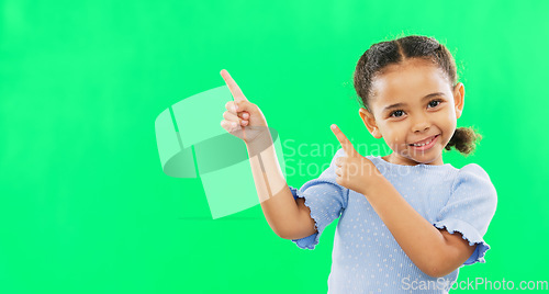 Image of Happy, pointing and mockup with girl in studio for product placement, promotion and offer. Choice, launch and smile with portrait of child on green background for brand, advertisement and display