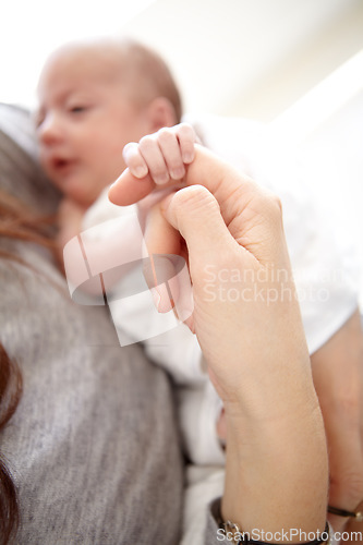 Image of Baby, mother and holding finger in closeup with love, care and bonding in morning sunshine at family home. Mama, infant child and together with hands, touch and connection with development in house