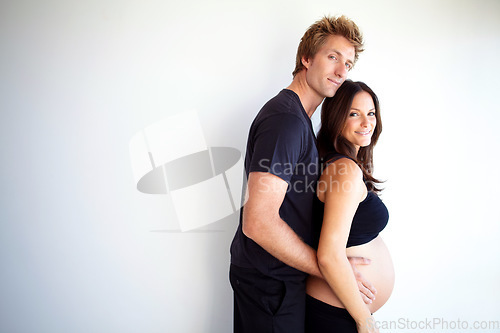 Image of Pregnant, hug and portrait of couple on a white background for love, care and support in studio. Future family, pregnancy and happy man and woman embrace excited for bonding, baby and parenthood