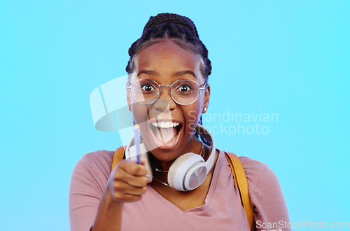 Image of Wow, thinking and aha with a black woman in studio on a blue background looking thoughtful or surprised. Idea, wonder and eureka with an attractive young female feeling shocked or contemplative