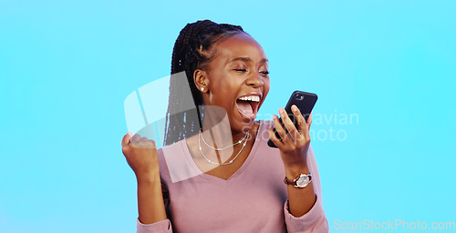 Image of Wow, happy and excited black woman with phone reading email news of bonus, promotion or announcement in studio. Winning, prize notification and African girl celebrating with smile on blue background