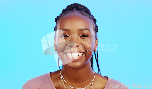 Image of Face, laughter and smile of a black woman in studio isolated on a blue background for fun or humor. Portrait, happy and laughing with an attractive young female enjoying a joke, comic or funny comedy