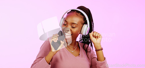 Image of Sing, dance and black woman with headphones music microphone isolated on a studio background. Fun, happy and funky African girl listening to audio, radio or songs while singing and dancing on a backd