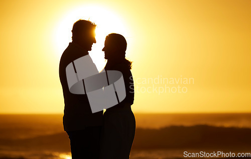 Image of Silhouette, couple and love at sunset on beach for vacation, holiday or mockup outdoor. Romantic man and woman hug in nature with creative sky background for affection, shadow art and travel freedom