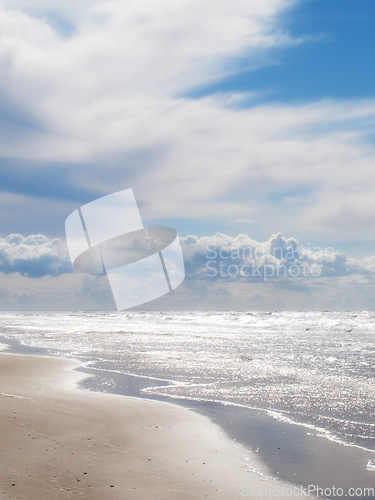 Image of Beach, clouds and blue sky by the ocean for travel with a seascape or tropical vacation in Australia. Nature, island and sea water waves with sand for an outdoor paradise holiday or weekend trip.