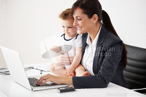 Image of Remote work, laptop and a mother with care of a baby while working, typing email and doing research. Happy, business and a mom with a computer for entrepreneurship while caring for a child in a house