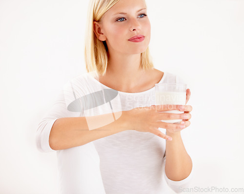 Image of Idea, milk and detox with a woman drinking from a glass in studio isolated on a white background. Idea, nutrition and calcium with a healthy young female enjoying a drink for vitamins or minerals