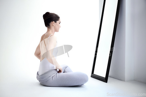 Image of Female ballerina stretching by a mirror in a studio before a dance class, performance or concert. Art, creative and back of young ballet dancer doing a body warm up for classical dancing in her room.