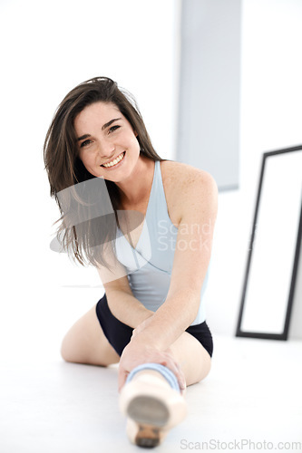 Image of Stretching legs, ballet and portrait of woman training in studio sitting on floor. Ballerina stretch, face and happy athlete from Canada warm up for exercise, dance and fitness, workout and practice.