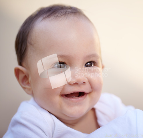 Image of Happy, closeup face of a baby with a smile and health wellness for childhood development. Happiness or excited, childhood or giggle for fun and toddler smiling for healthcare with laugh for comedy