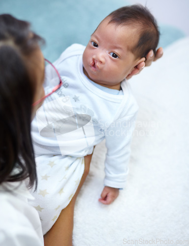 Image of Family, mother and a baby with a cleft lip in the bedroom of their home together for love or care from above. Healthcare, medical and female child with a disability in the arms of her mama in a house