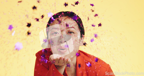 Image of Studio, asian woman blowing confetti and celebration for birthday, anniversary or celebrating Chinese new year. Happy party, smile and model from china on yellow background to celebrate with glitter