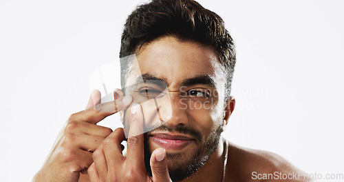 Image of Pimple pop, Indian man and struggling model doing skincare and wellness routine for acne. Isolated, white background and beauty treatment for dermatology, skin glow and face cleaning for pimples