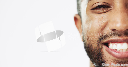 Image of Face, closeup and man in studio for skincare, happy and laughing against white background. Zoom, smile and portrait of Indian male model excited for wellness, beauty and cosmetic care while isolated