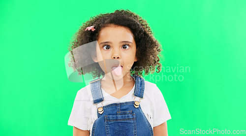 Image of Little girl, silly and goofy face on green screen with facial expressions against a studio background. Portrait of female child or kid making funny faces with tongue out for childhood youth on mockup