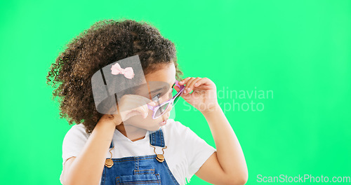 Image of Green screen, fashion and child looking with sunglasses for trendy, stylish clothes and accessories. Emoji face, happy and portrait of girl with funny, comic and humour facial expression in studio