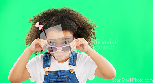 Image of Portrait, green screen and a girl looking over her glasses in studio to ask a question with attitude. Kids, fashion and eyewear with an adorable little female child on chromakey mockup for style