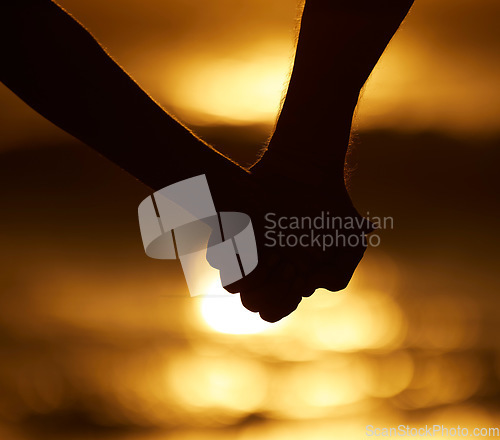 Image of Couple, silhouette and holding hands at sunset on a beach for vacation or holiday outdoor. Closeup of man and woman in nature for peace, calm and love at ocean for creative shadow, travel or freedom