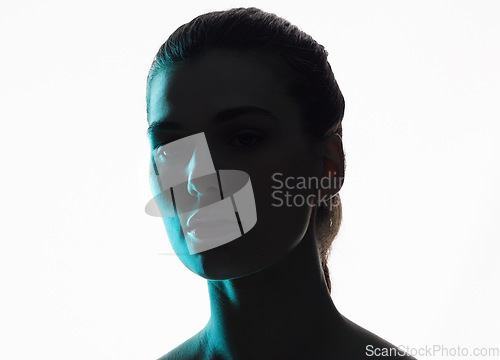 Image of Silhouette, portrait and woman in neon shadow with dark lighting or posing in studio in futuristic glow and isolated in studio. Aesthetic, creativity and face model in blue color design on background