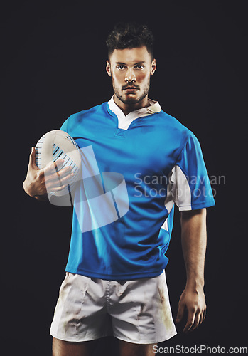 Image of Rugby, black background and portrait of man athlete with ball in dark studio while training in dirt for wellness and fitness. Exercise, workout and professional sports career of male person or player