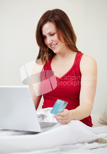 Image of Laptop, bed and woman with credit card for online shopping, payment or digital banking in home. Ecommerce, bedroom and happy person on computer for finance, internet sales on web store and fintech.