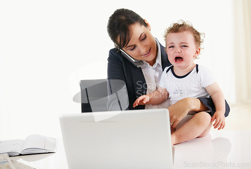 Image of Woman, home office and phone call with kid, laptop and care with talk, reading and multitasking at desk. Mother, baby boy and cellphone for networking, crying and remote work at pc in family house