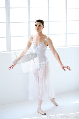 Image of Dance, ballet and focus with woman in studio for balance, elegant and performance. Artist, theatre and training with female ballerina dancing in class for competition, freedom and commitment