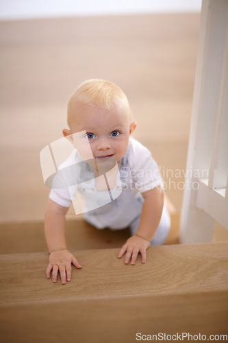 Image of Happy, portrait of baby crawling and at his home with a smile at the stairs. Happiness or childhood development, excited or cheerful and boy child crawl at his house by the staircase smiling