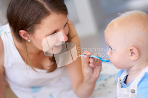 Image of Mother, baby and feeding food, breakfast and eating for healthy nutrition in home. Happy mom, newborn and feed hungry child, infant or toddler meal with a spoon for growth, development and wellness.