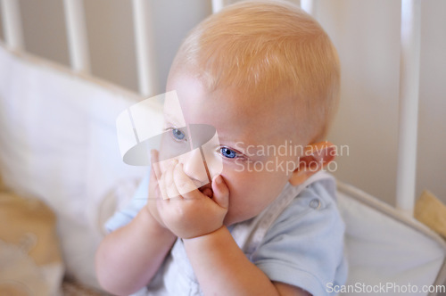 Image of Happy, face and toddler standing in crib, bedroom or excited baby boy with hands on teething mouth for morning surprise of mistake. Kid sitting in cot, awake and healthy bed routine for young child