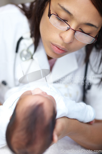 Image of Healthcare, medical and a pediatrician with a baby in the hospital for insurance, care or treatment. Medicine, children and a doctor woman holding a newborn infant in a health clinic for a checkup