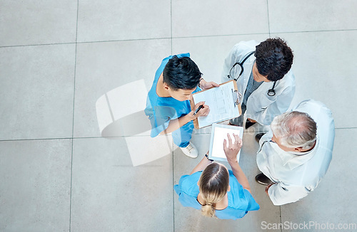 Image of Healthcare, doctors and group meeting with a tablet for discussion, planning or research. Above men and women medical staff talking about team collaboration, online schedule or surgery in a hospital